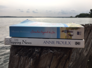 Spines of books The Shipping News by Annie Proulx and Somewhere Beyond the Sea by Miranda Dickinson, PCG Books, on driftwood posts overlooking Lake Simcoe.