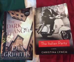 Books The Dark Angel by Elly Griffiths and The Italian Party by Christina Lynch laying face up on the colours of the Italian flag - green, white and red.