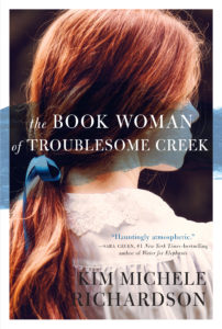 Auburn-haired woman looking off the side of the book cover with a stroke of blueberry blue across her face.